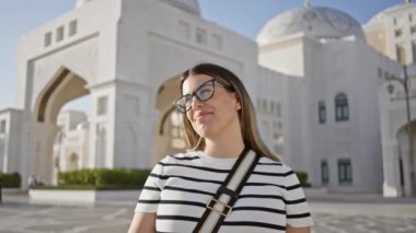 Abu Dabi 'deki Qasr al Watan Sarayı' nda gözlüklü gülümseyen kadın turizmden zevk alıyor.