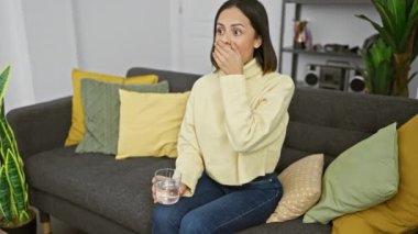 Ağzı açık, elinde su bardağı olan genç, şaşkın İspanyol kadın güzel yüzüne inanamadı.