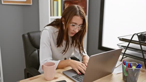 若いブルネット女性は 現代のオフィスでラップトップに取り組んでいる間 彼女の首を握ります — ストック動画