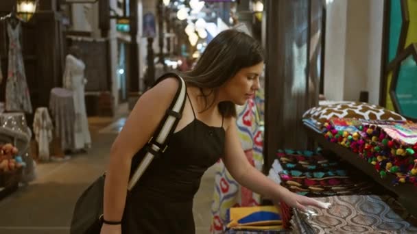 一位面带微笑的女士在杜拜的Souk Madinat Jumeirah探索五彩缤纷的纺织品 象征着旅游业和文化 — 图库视频影像