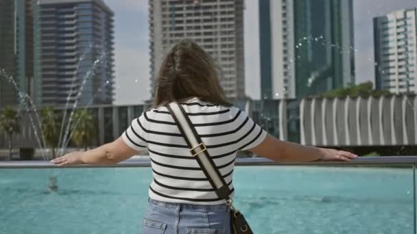 一位年轻的黑发女子喜欢杜拜的未来派都市景观 现代建筑塑造了她那欢快的表情 — 图库视频影像