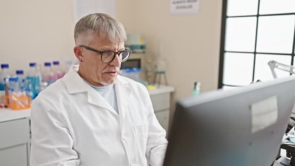 Siwowłosy Naukowiec Zdejmuje Okulary Zestresowany Podczas Pracy Nad Laptopem Laboratorium — Wideo stockowe