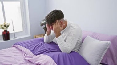 Hüsrana uğramış genç İspanyol pijamalı adam, yatak odasında yatıyor, çılgın bir ifadeyle çılgına dönüyor, bağırıyor, kollarını sallıyor.