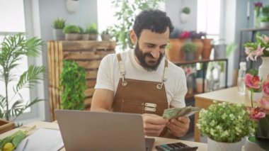 Çiçekçide uae dirhem sayan orta yaşlı bir adam..
