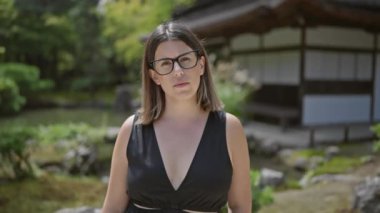 Düşünceli ve güzel İspanyol gözlüklü kadın, Ginkaku-ji Tapınağı, Kyoto 'da dirençle ayakta duruyor; Japonya' nın zirve bahçesi arasında zen portresi