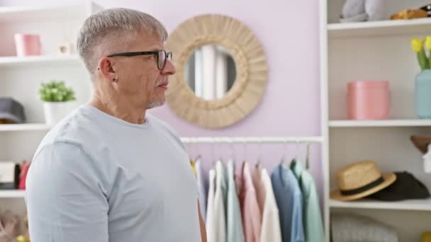 Reifer Mann Mit Brille Steht Nachdenklich Einer Hellen Kleiderkammer Und — Stockvideo