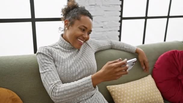 Uśmiechnięta Kobieta Korzystająca Smartfona Domu Prezentująca Technologię Komfort Nowoczesnej Przestrzeni — Wideo stockowe