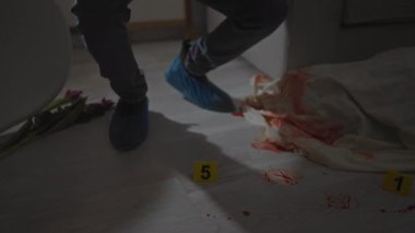 Olay yerini evin içinde inceleyen bir adamla yoğun bir sahne. Delil işaretleri, kan lekeleri ve adli aletlerle dolu..