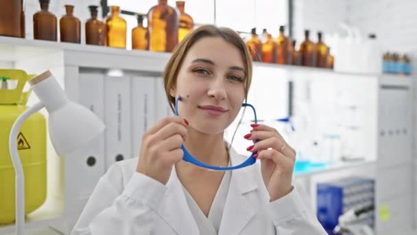 Young Woman Wearing Safety Glasses Laboratory Setting Chemical Bottles Background — Stock Video