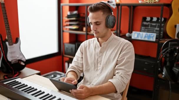 Joven Hispano Con Auriculares Usa Una Tableta Vibrante Estudio Música — Vídeos de Stock