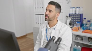 Üniformalı neşeli, genç İspanyol bilim adamı laboratuvarda bir numaralı fikri ateşledi! Bilgisayar sihirbazı, mutlu bir şekilde işaret ediyor, zeki zihninde sorular sorup duruyor..