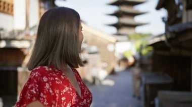 Neşeli, güzel İspanyol kadın Kyoto 'nun eski lejyon sokağında gülerek, geleneksel ahşap pagoda önünde poz verirken pozitif duygular ve gerçek neşe yayıyor..