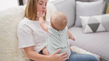 Annesinin sevgi dolu gülümsemesi, kızıyla birlikte evde rahat bir hayat sürerken neşeli bir kahkahayla gülmesi.