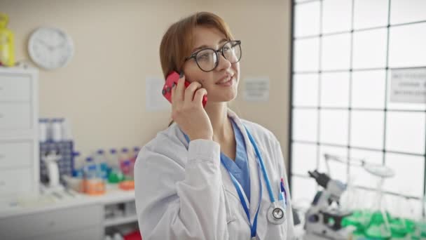 一家诊所的一位年轻的专业女医生在室内用智能手机进行交流 — 图库视频影像