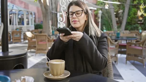 Женщина Пользующаяся Смартфоном Открытым Столиком Кафе Наслаждается Кофе Воплощая Современный — стоковое видео