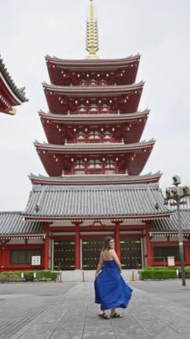 Neşeli İspanyol kadın, Senso ji Tapınağı 'nın Tokyo' daki görkemli mimarisi arasında güzel elbiseler içinde neşeyle dans ediyor. Japonya 'yı gezerken, şehir maceralarında mutluluk saçar..