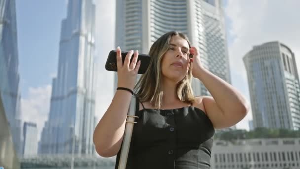 一个年轻的女人拿着智能手机 欣赏着杜拜的摩天大楼 — 图库视频影像
