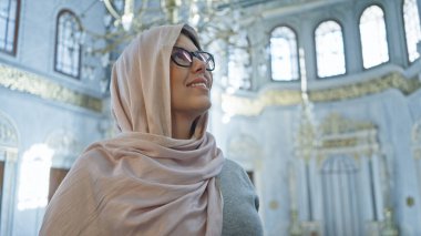 Müsrif İstanbul Camii 'nin içinde tesettürlü, tesettürlü, karmaşık İslami mimarisi olan bir kadın.