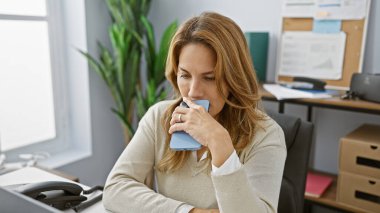 Modern ofiste telefonu tutan düşünceli İspanyol kadın profesyonel ve düşünceli bir yetişkin gibi davranıyor..