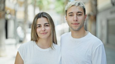 Gülümseyen güzel bir çift sokakta bir arada duruyor.