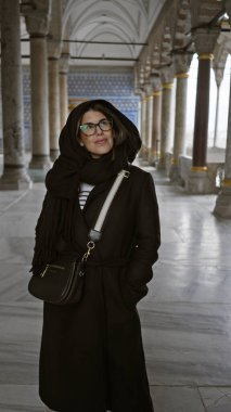 İstanbul 'da tarihi Topkapı Sarayı' nda poz veren gözlüklü gülen kadın.