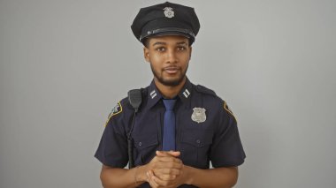 Beyaz bir arka plana yapışmış yakışıklı Afro-Amerikan polis memuru..