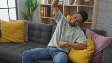 Keyifli bir adam rahat bir oturma odasında rahat bir kanepeye uzanıyor.