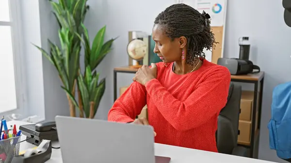 African Woman Red Sweater Experiencing Shoulder Pain While Working Her — Stock Photo, Image