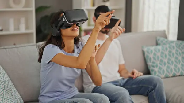 这对年轻漂亮的夫妇沉醉在爱情与游戏中 在家里用电子游戏小玩意体验了3300伏的生活 — 图库照片