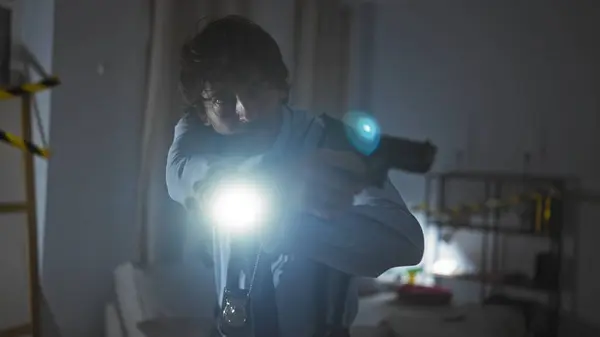 在昏暗的室内犯罪现场用手电筒瞄准枪的西班牙侦探 — 图库照片
