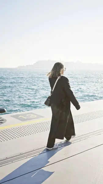 Young Woman Coat Strolls Sunny Seaside Promenade Waves Background — Stock Photo, Image