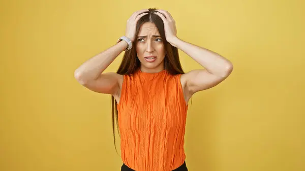Perplexed Young Woman Orange Top Clutching Her Head Solid Yellow — Stock Photo, Image