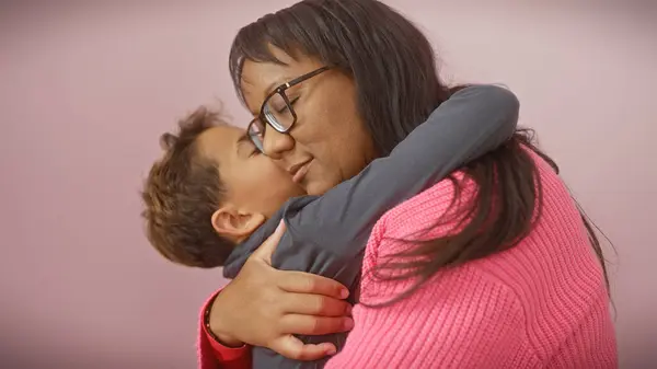 Una Madre Cariñosa Abraza Hijo Sobre Fondo Rosa Aislado Simbolizando —  Fotos de Stock