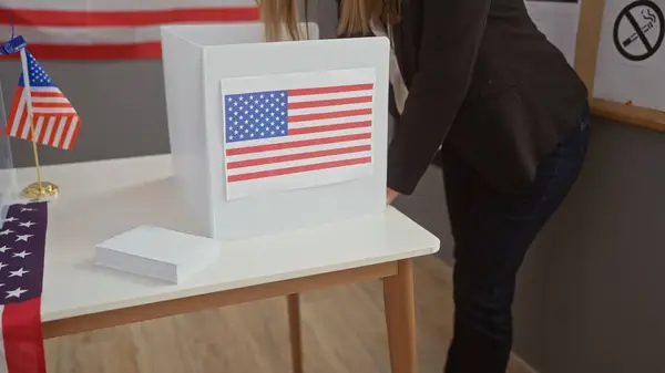 アメリカの選挙ブースで投票した女性 彼女の背後にあるアメリカの国旗 — ストック写真