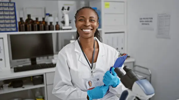 Una Mujer Científica Afroamericana Confiada Con Portapapeles Guantes Posa Laboratorio — Foto de Stock