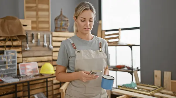 Blonde Woman Apron Texting Carpentry Workshop Coffee Mug — Stock Photo, Image