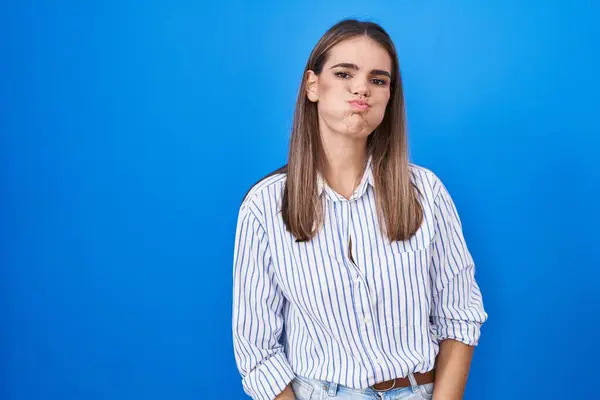 Mujer Joven Hispana Pie Sobre Fondo Azul Hinchando Mejillas Con — Foto de Stock
