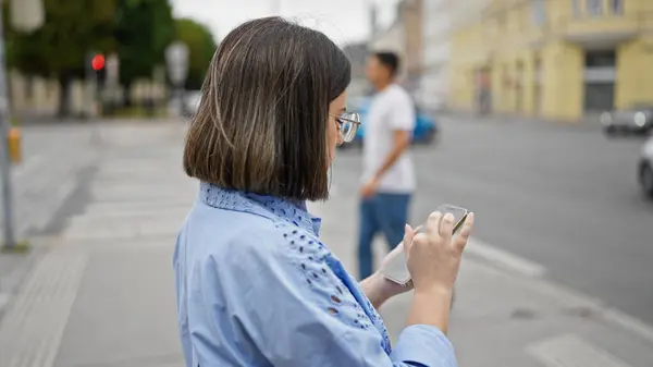 在维也纳街上用智能手机的年轻而美丽的惊慌失措的女人 — 图库照片