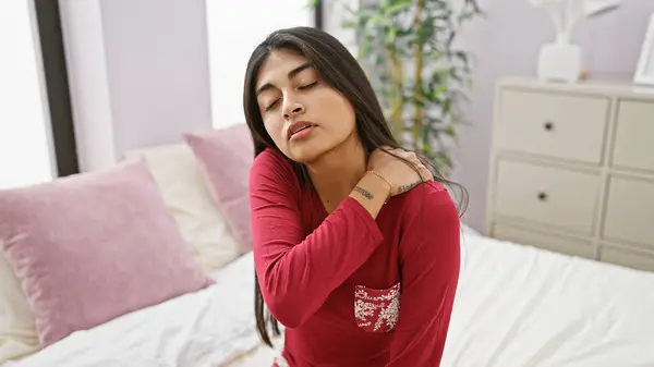 stock image A serene south asian woman relaxes in a modern bedroom with eyes closed, evoking peace and comfort.