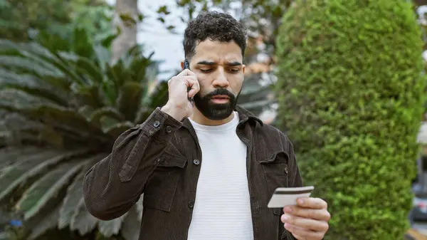 Латиноамериканец Бородой Разговаривает Телефону Держа Кредитку Улице Городском Парке Стоковая Картинка