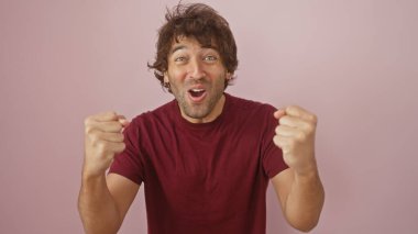 Heyecanlı, sakallı, pembe bir arka planda izole edilmiş İspanyol bir adam..