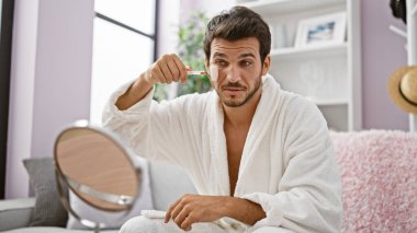 Beyaz bornozlu yakışıklı bir adam evde otururken elinde yeşim bir arabasıyla geziyor..