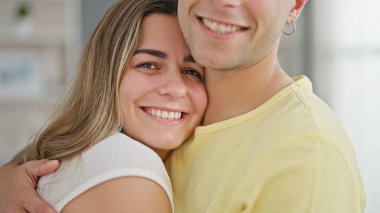 Güzel bir çift gülümsüyor. Evde birbirlerine sarılıyorlar.