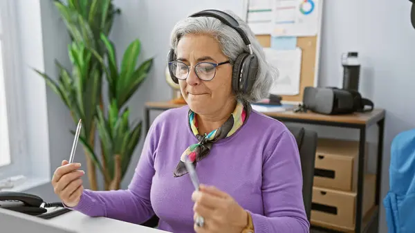 Grey Haired Woman Headphones Enjoys Music While Holding Pen Modern — Stock Photo, Image