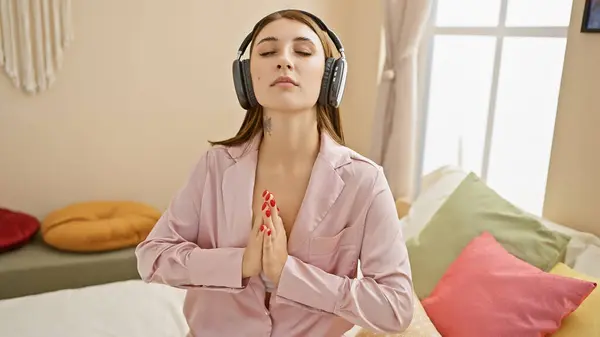 Pembe Pijamalı Rahat Yatak Odasında Kulaklıklarıyla Yatakta Meditasyon Yapan Dingin — Stok fotoğraf