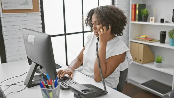 有辫子的非裔美国女人打电话 在办公室里用电脑 — 图库照片