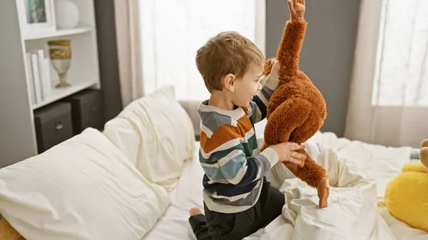 Blond Jongetje Spelen Met Teddybeer Bed Een Gezellige Slaapkamer Setting — Stockfoto