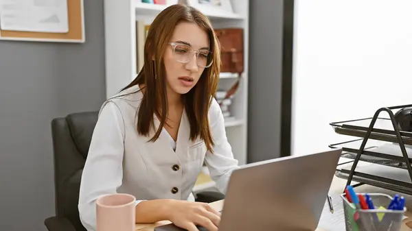 Focused Young Woman Working Laptop Modern Office Setting Exemplifying Professionalism — Stock Photo, Image