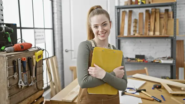 Smiling Young Blonde Woman Holds Yellow Clipboard Well Equipped Woodworking — Stock Photo, Image