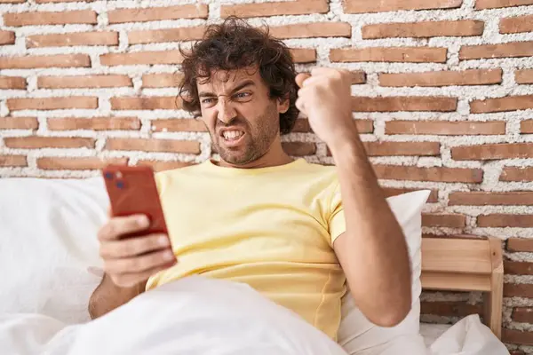Spaanse Jongeman Met Behulp Van Smartphone Het Bed Geïrriteerd Gefrustreerd — Stockfoto